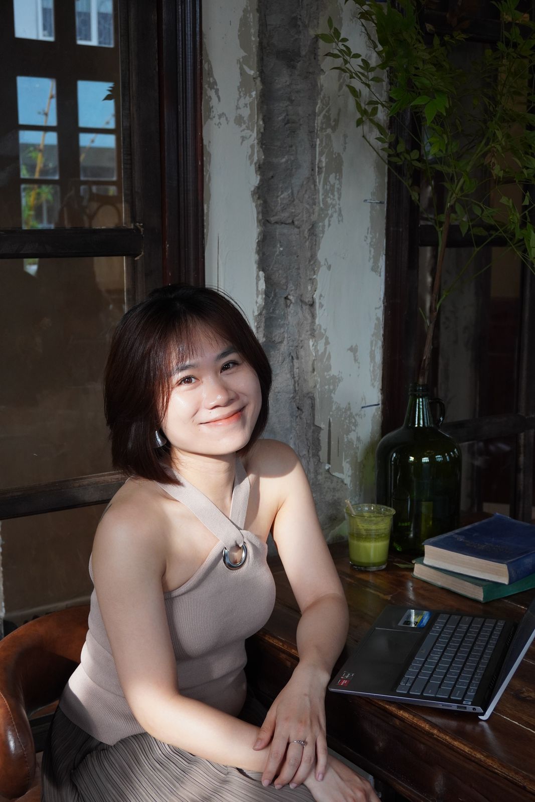 Hoa ngồi bên bàn làm việc gỗ