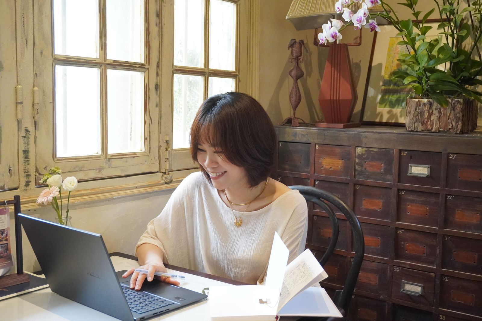 Hoa mỉm cười bên laptop