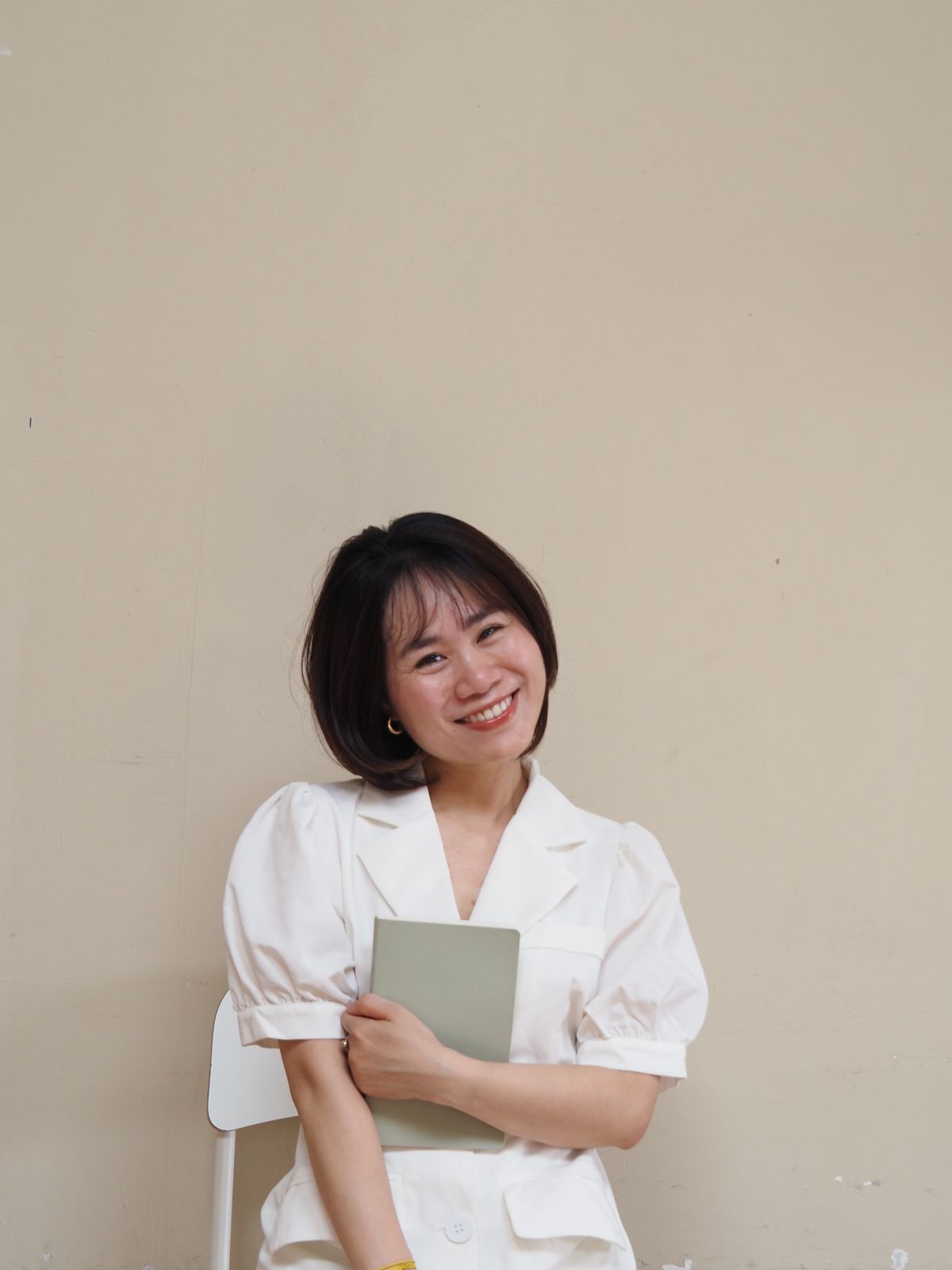 Chân dung Hoa mỉm cười, ôm cuốn sổ