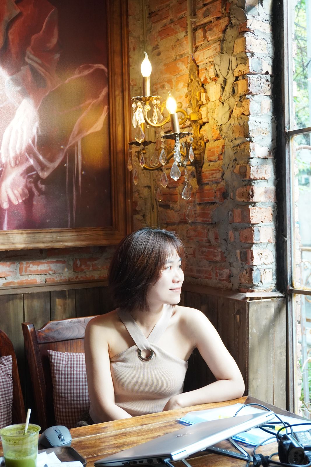 Hoa ngồi bên cửa sổ trong quán cà phê